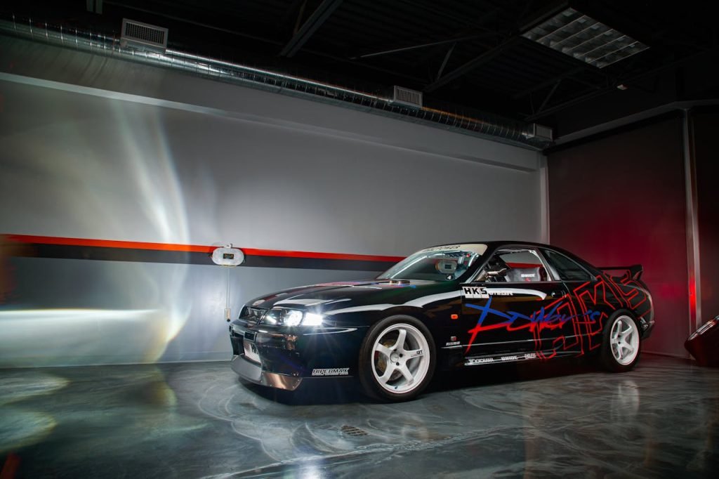 A stylishly modified Nissan Skyline sports car showcased indoors with striking decals.