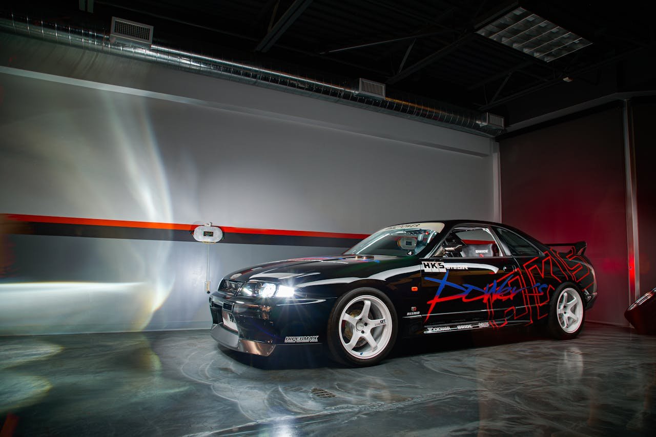 A stylishly modified Nissan Skyline sports car showcased indoors with striking decals.